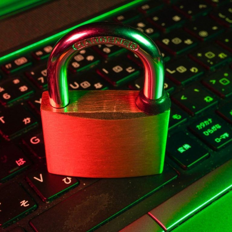 A metallic padlock placed on a keyboard with colorful lighting.